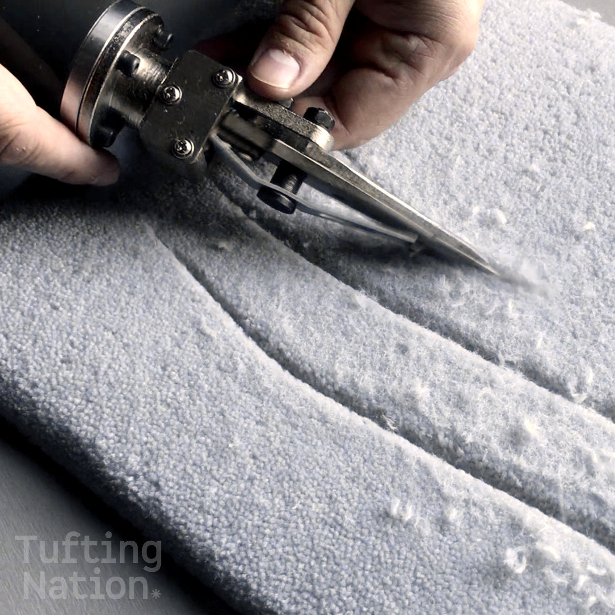Electric Rug Carving Scissors in action, sculpting lines into a tufted rug made of wool rug yarn